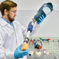 young prosthetist holding artificial leg